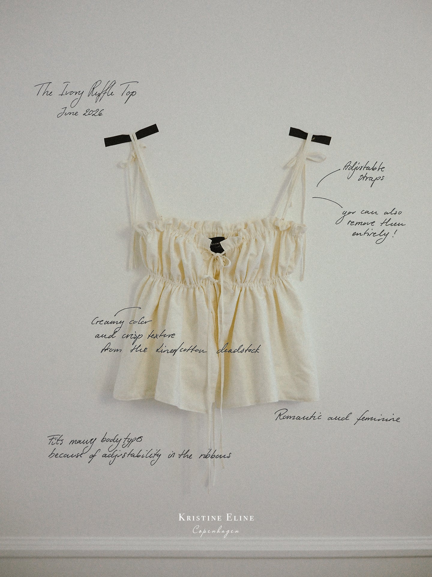 Ivory ruffled top sat with black tape on white wall with text and scribbles on top.