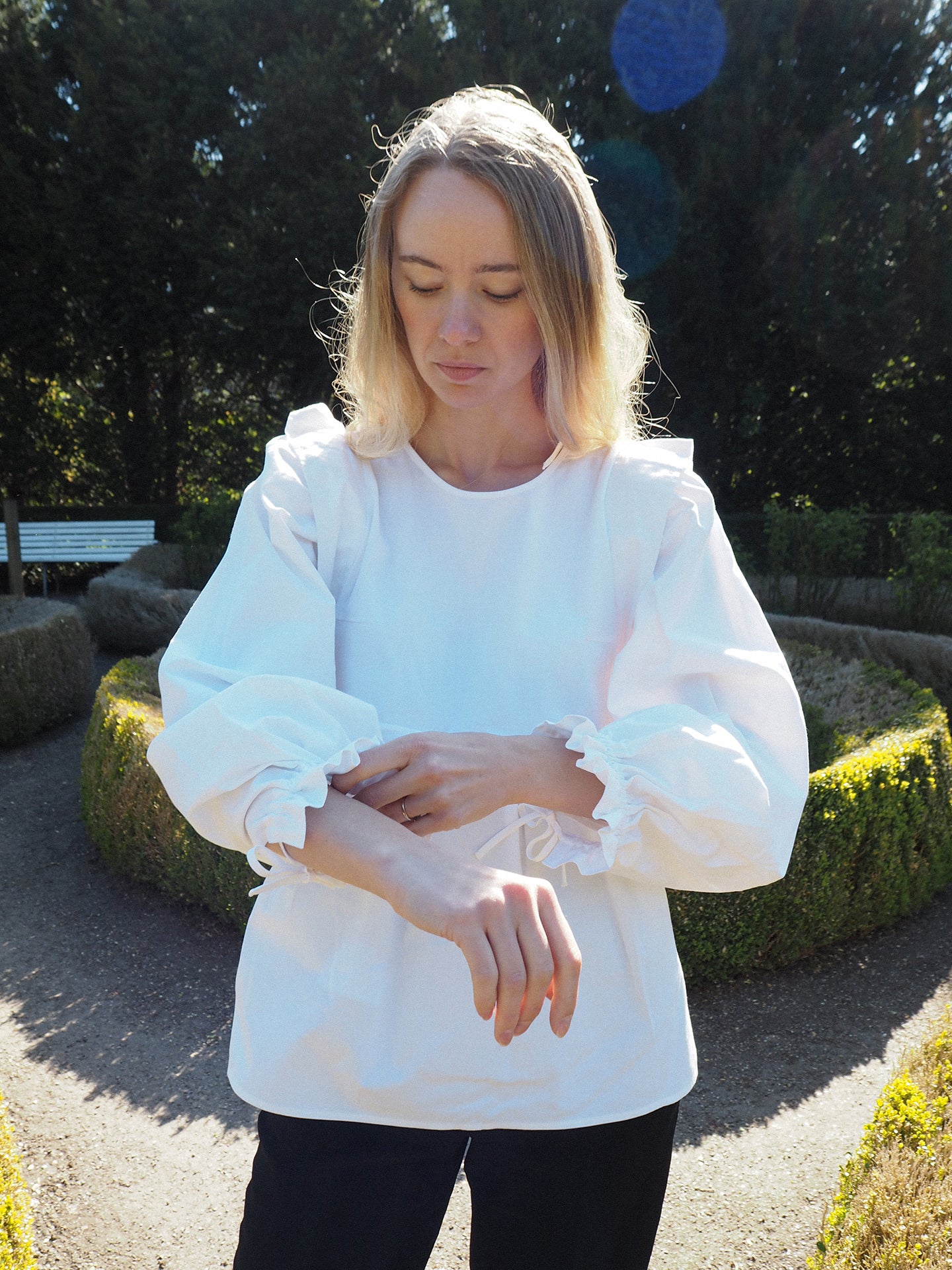 Girl wearing a white blouse with puffed sleeves outdoors.