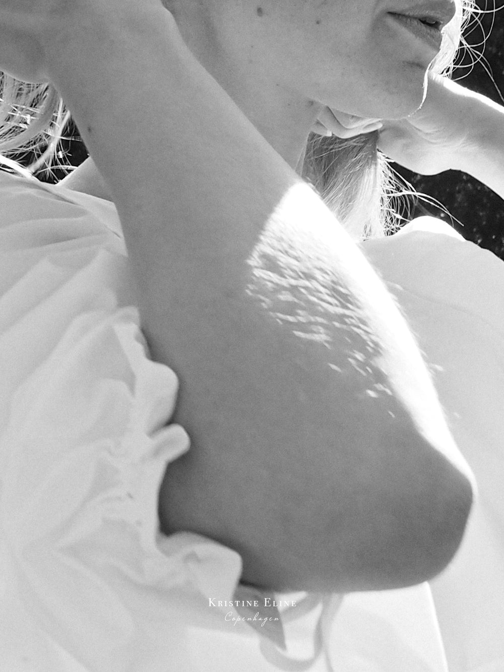Close-up of a person wearing a white dress with a blurred background in black. and white