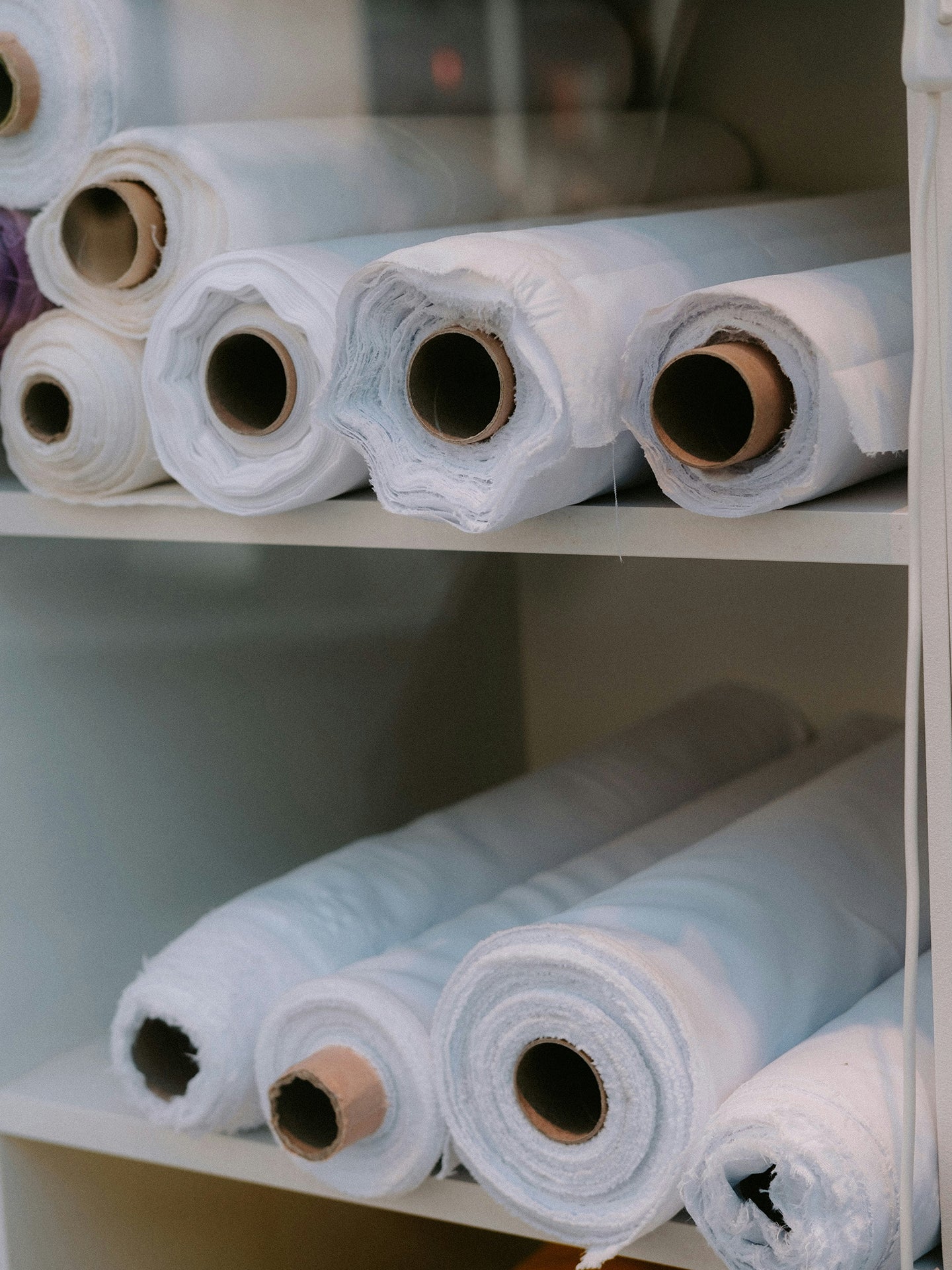 Rolls of fabric on a shelf in a storage room