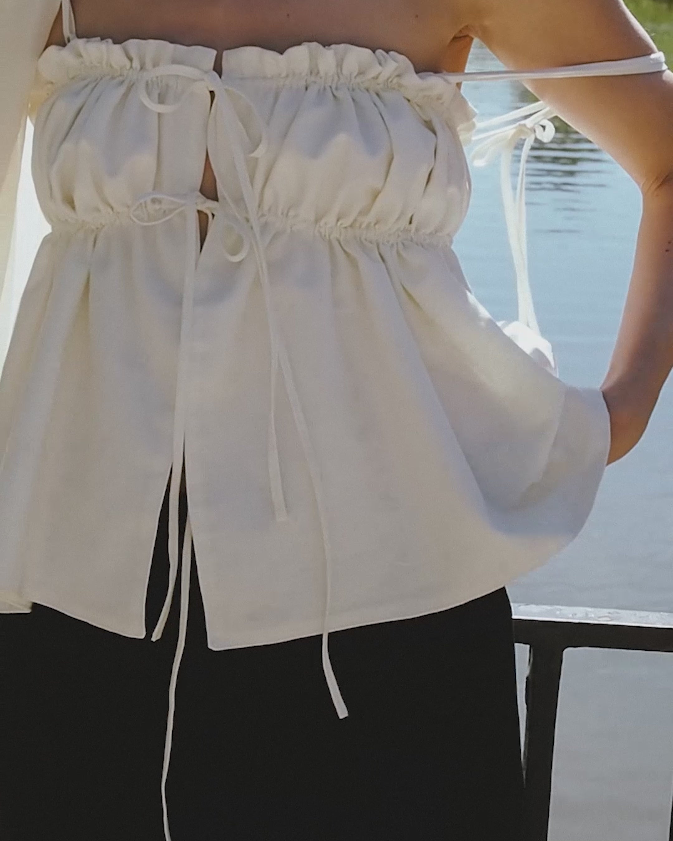 Load video: video of model wearing The Ivory Ruffle Top